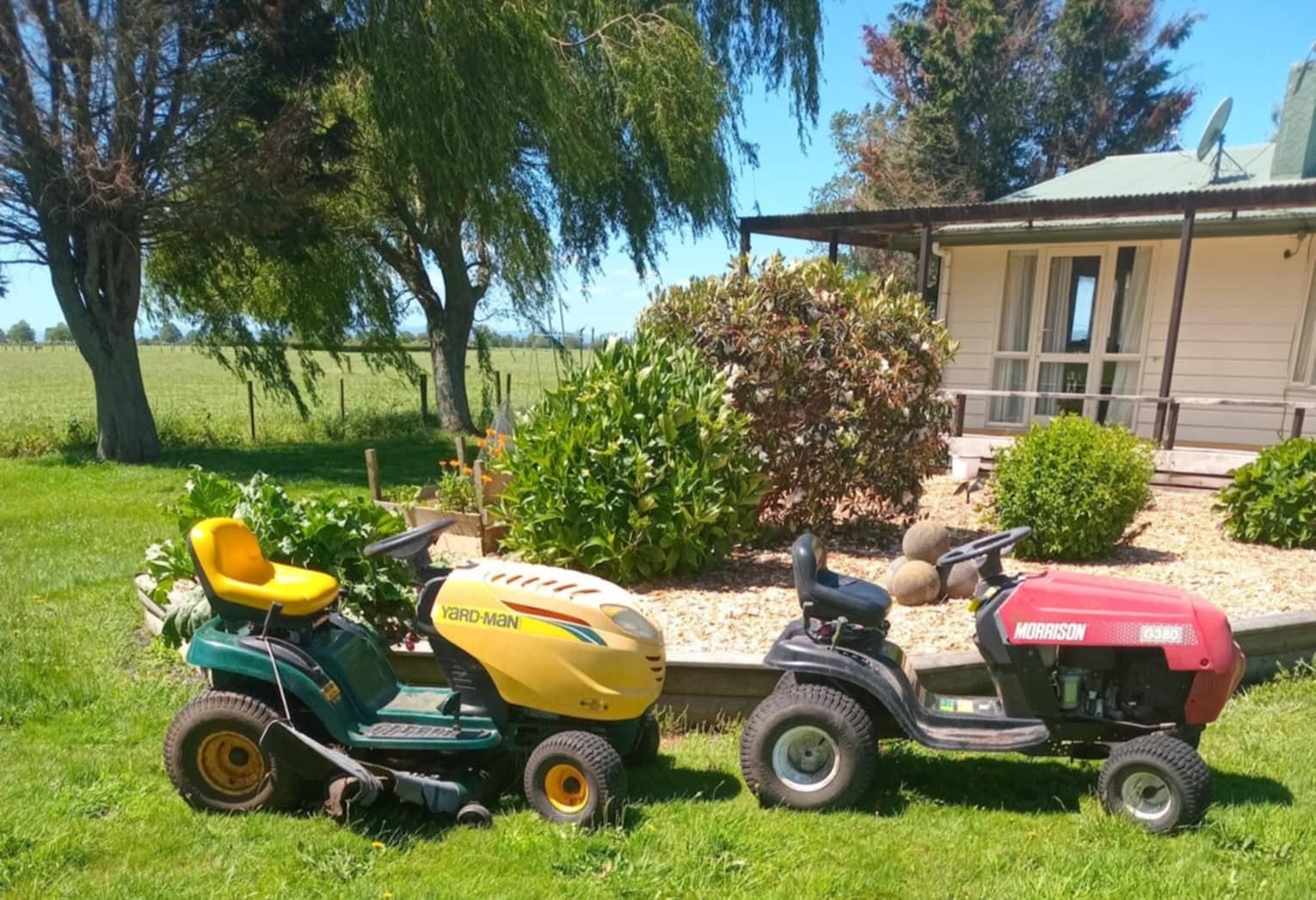 Two ride-on mowers on a lawn in the Waikato